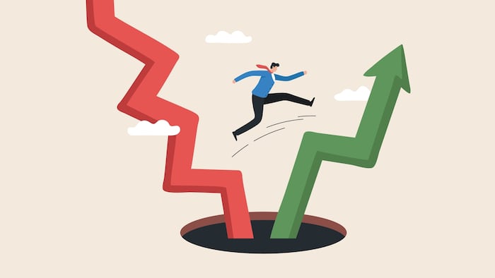 Person jumping over a hole, depicting financial volatility