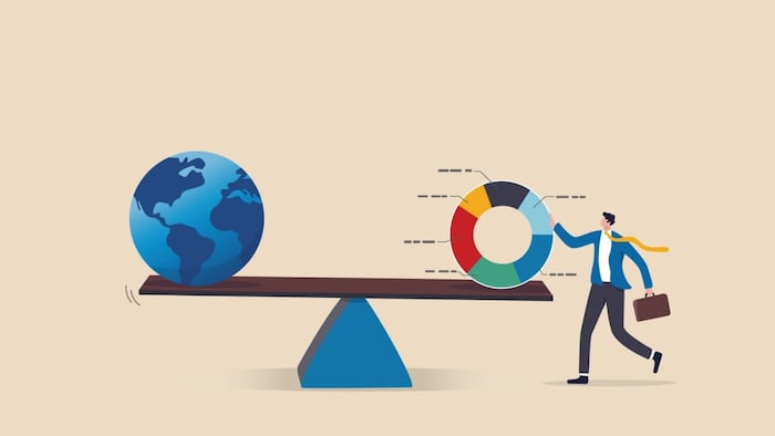 scale with earth on one side and businessman holding circle graph divided into various segments on the other side