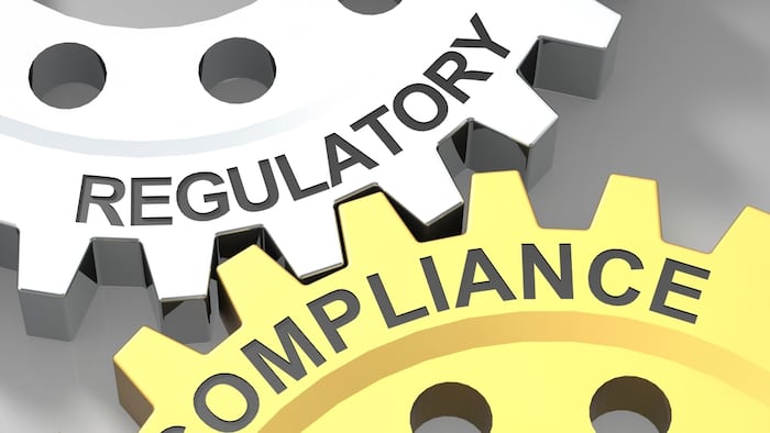 Regulatory compliance written on turning wheels