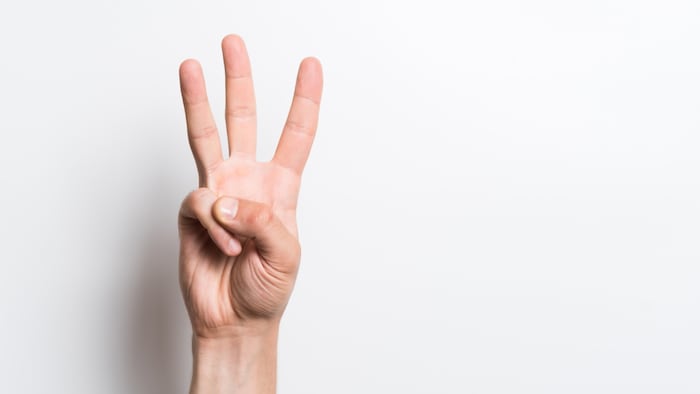 Person holding up three fingers